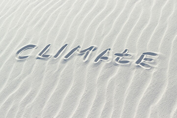Fototapeta na wymiar climate written with finger on white sand, word climate change concept on sand