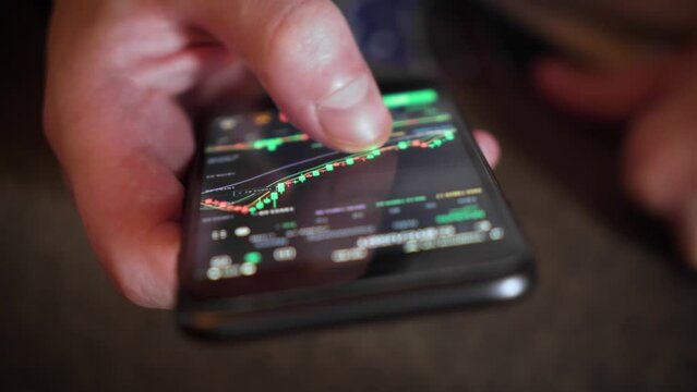Businessman checks a price chart on a digital exchange on a mobile phone screen. close-up.