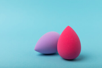 Beauty blender.Colorful beauty sponges on blue background. Cosmetic tool for applying and blending products such as foundation and concealer. Copy space. place for text.