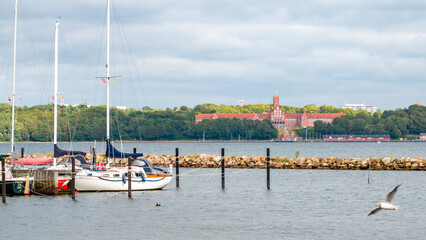 boats in the foreground. Midground port. Buildings in the background. Cloudy sky. Harrislee,...