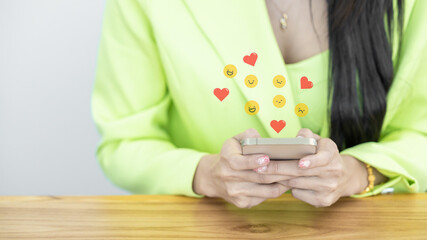 Close up Asian businessman using smartphone sending emojis, Asian woman holding and using smart...