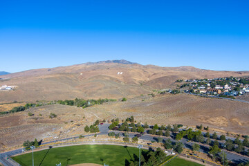 Aerial view of mountains near Reno Nevada with a large painted "N" for the University of Nevada and a blue sky with copy space.