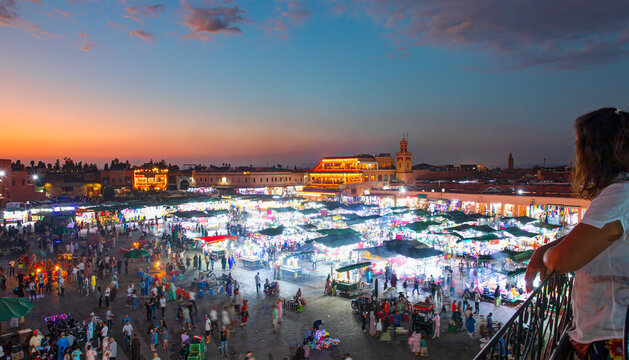 The Jema el Fna square in the background Koutoubia Mosque minaret at medina quarter at dusk with crescent moon - Marrakesh, Morocco
