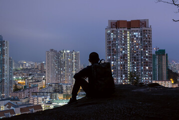 香港の夜景を嘉頓山から観る男性　コピースペース　Silhouette of man enjoying night view of Hong Kong from Garden Hill