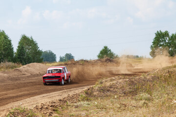 Obraz na płótnie Canvas Rally off-road car make a turn with the clouds and splashes of sand, gravel and dust during rally championship
