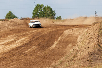 Rally off-road car make a turn with the clouds and splashes of sand, gravel and dust during rally championship