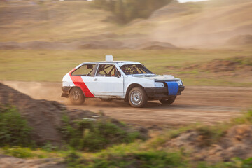 Obraz premium Rally off-road car make a turn with the clouds and splashes of sand, gravel and dust during rally championship