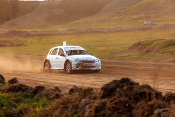 Rally off-road car make a turn with the clouds and splashes of sand, gravel and dust during rally...