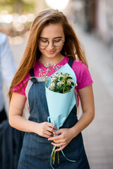 great view on woman with bouquet of chamomile and other flowers in wrapping paper