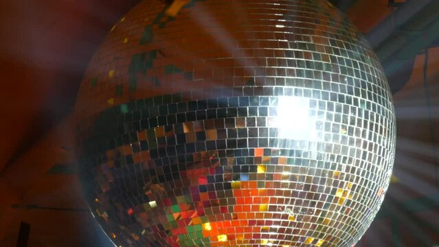 Silver mirror disco ball at a party or celebration. Lighting design on the stage of the birthday party in the club. Abstract background of retro disco ball