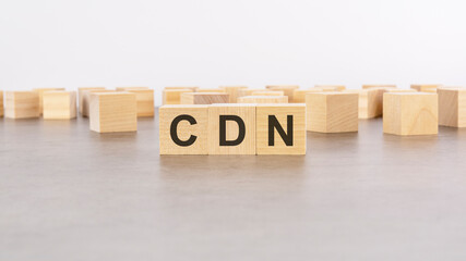 three wooden blocks with letters CDN - Content Delivery Network - with focus to the single cube in the foreground