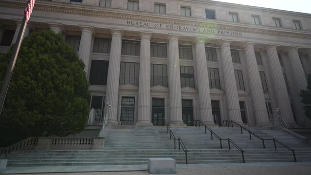 Front facade of the Bureau of Engraving and Printing in Washington, DC part of the Department of the Treasury with blue sky.