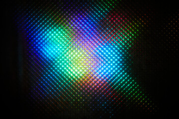 Fototapeta premium Blurred abstract colorful pattern. Light glares with a spectral gradient on a dark background.