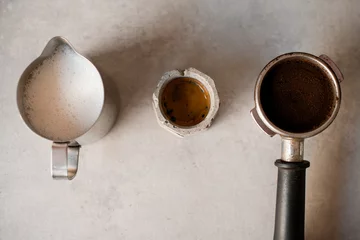 Crédence de cuisine en verre imprimé Bar a café Vue de dessus en gros plan du support avec porte-filtre plein de café moulu et tasse avec boisson et pichet avec du lait