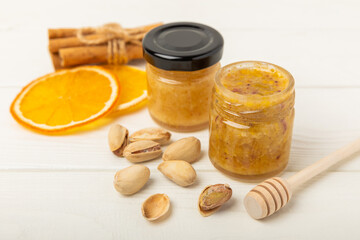 Pistachio honey on white texture wood. Assorted honey. Honey in pistachios and almonds. Environmentally friendly product. Vitaminized jam. Cold remedy.Copy space