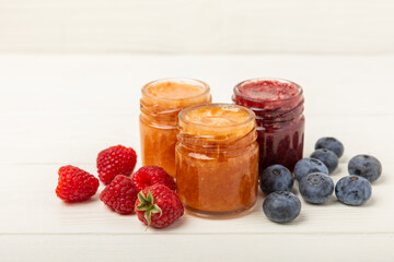 Honey in a glass jar. Raspberry and blueberry honey jam. Remedy for colds and respiratory diseases. Organic product of a vegetarian diet. copy space. copy space