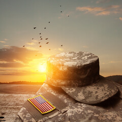 USA military uniform with insignias on old wooden table on sunset sky background with flying birds....