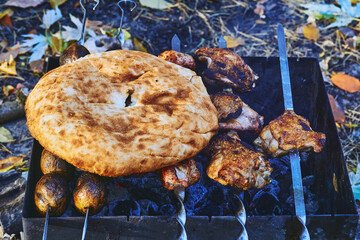 East caucasian bread lavash pita and meat on a grill grate on a fire
