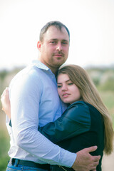 Fototapeta premium A couple of a tall young man and his girlfriend with long blond hair are walking in the city in nature. Emotions and feelings. Life style