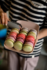 french macarons on tray in female hands.