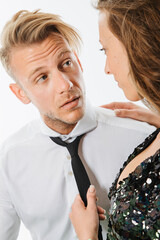 woman flirt with male colleague while tie his necktie and look flirty to his eyes while he is...