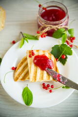 fried bread croutons for breakfast with redcurrant jam in a plate with berries