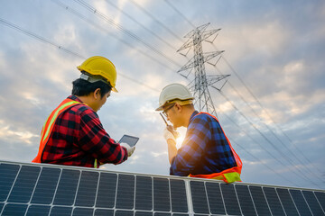 A team of two male electrical engineers using tablets to watch power stations and solar...