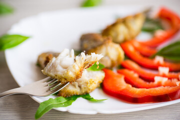 Pieces of fried hake fish in a plate with pepper