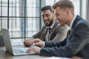 Fototapeta premium Two happy men working together on a new business project
