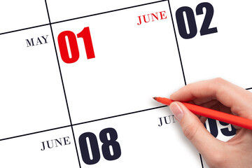 A hand holding a red pen and pointing on the calendar date June 1. Red calendar date, copy space,...