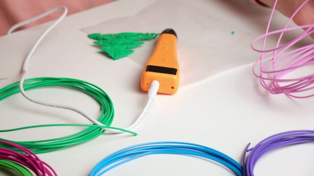 Teen Girl Using 3d Pen. Printing with Colored Plastic Wire Filament. Child making a Christmas Three, drawing with 3D pen. Artwork, Robotics. STEAM, STEM education. Modern Technologies. Study at home.