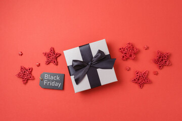 Black Friday sale banner concept, Gift box with black ribbon bow on red background. Top view, flat lay