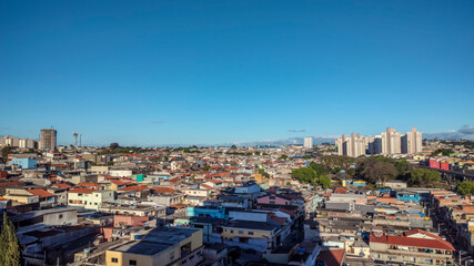 Vista da sombra de um prédio alto sobre as casas, Zona Leste, São Paulo, Brasil