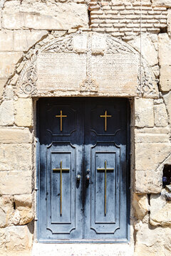 Grey door in an old wall of the Saint Mikheil Tvereli church in Tbilisi, Georgia, Europe