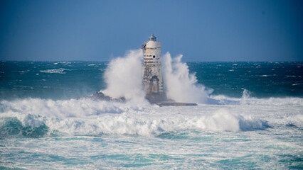 The lighthouse of the Mangiabarche shrouded by the waves of a mistral wind storm
