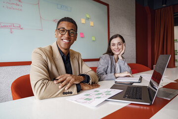 Smiling coworkers cooperating and working together at coworking space, teamwork concept