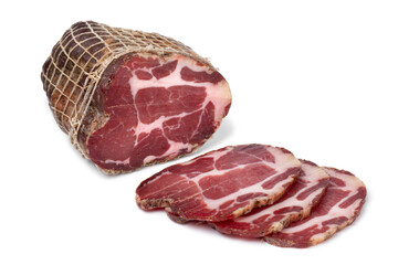 Piece and slices of traditional Croatian dried pork neck, pork collar bacon, isolated on white background