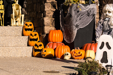 Halloween outdoor decorations outside haunted house with pumpkins, ghosts, spider webs, and...