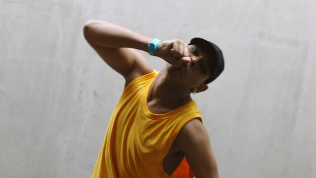 Creative, art and urban dancer with man training for hip hop, energy and fitness practice in city street and wall background. Motivation, exercise and moving with young guy dancing for creativity