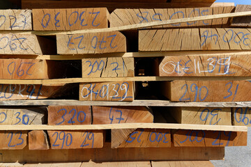 Wood texture.Stack of wood planks on lumber yard. lumber industrial wood texture timberwooden planks in close-up at a lumber warehouse. Background of boardsStack wooden studs, industrial wood lumber 