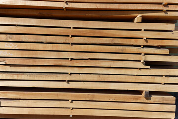 Wood texture.Stack of wood planks on lumber yard. lumber industrial wood texture timberwooden planks in close-up at a lumber warehouse. Background of boardsStack wooden studs, industrial wood lumber 