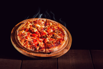 Hot pizza on a wooden board, with BBQ chicken, mozzarella, roasted garlic and marinara sauce, on a brown blackground,