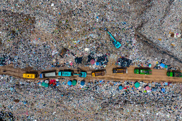 Garbage trucks unload garbage over the landfill. Pollution concept.
