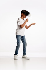 School age boy wearing casual style outfit enjoying 3D technology in virtual reality headset isolated on white background