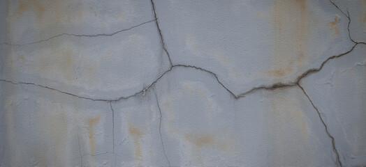 Old gray cement wall with cracks on the surface.
