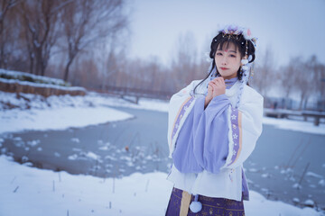 Fototapeta na wymiar A girl wearing Hanfu outdoors in winter
