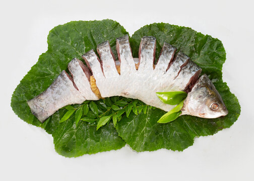 The rohu, rui, or roho labeo is a species of fish of the carp family, found in rivers in South Asia. Fish market display. raw, uncooked, sliced and top view with leaves.