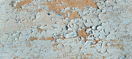 An old wall with blue peeling paint. Abstract textured wall background.