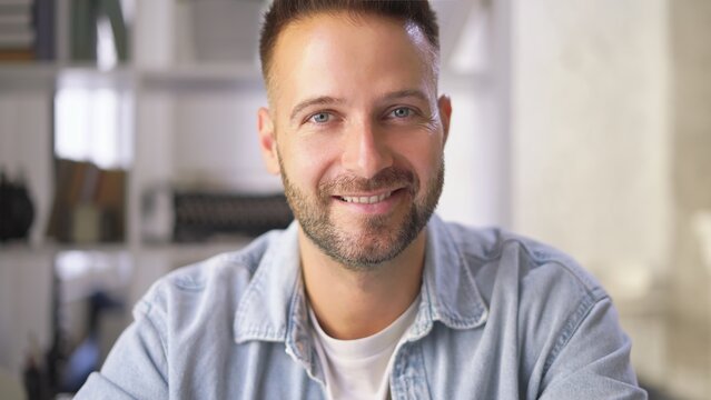 Portrait of young adult man at home. Happy, confident, smiling.