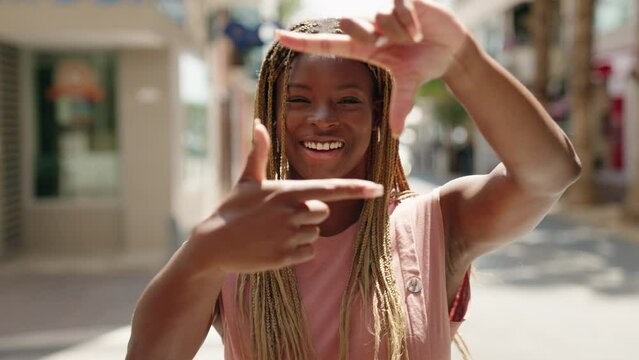African american woman smiling confident doing photo gesture with hands at street